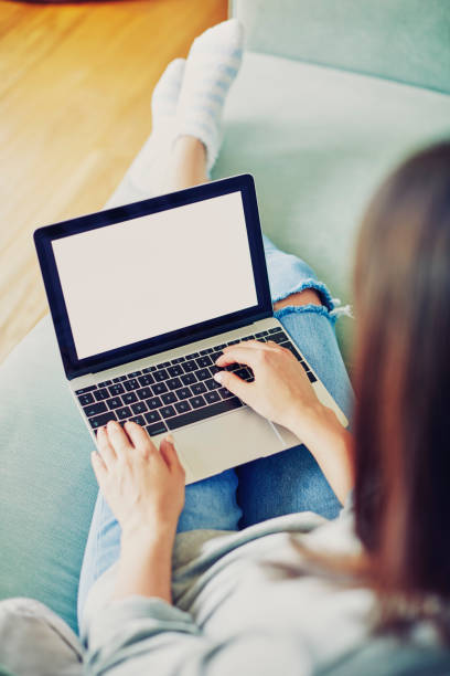 istock Fashionable woman using laptop while sitting on sofa at home 858311830
