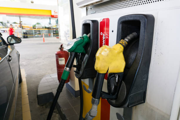 buses de remplissage à une station d’essence shell - gas station service red yellow photos et images de collection