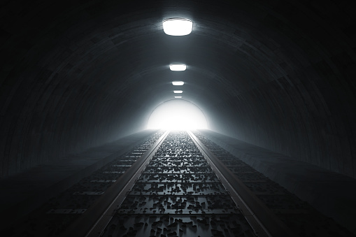3d rendering of darken train tunnel with light at the end