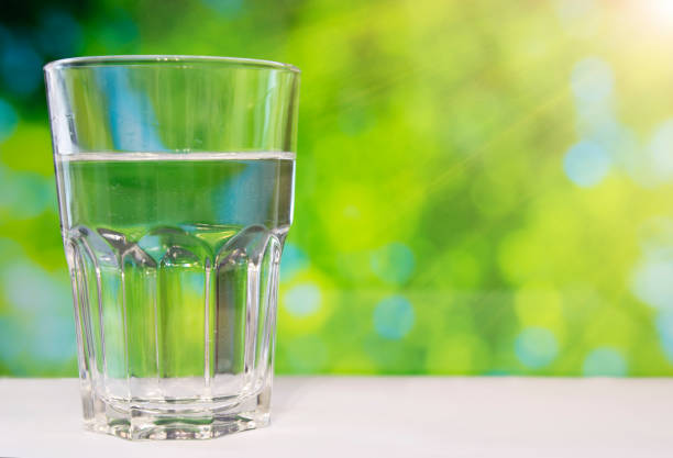 istock Faceted glass of water on nature background. 858315528