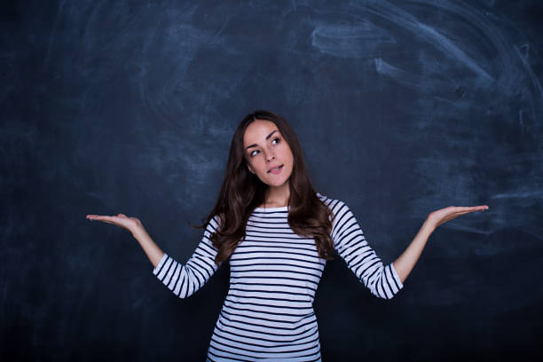istock Thoughtful businesswoman on blank chalkboard background 858326598