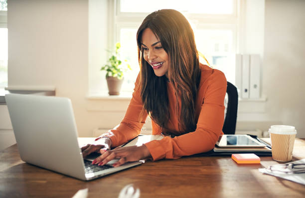 istock Smiling woman working on a laptop in her home office 858340610