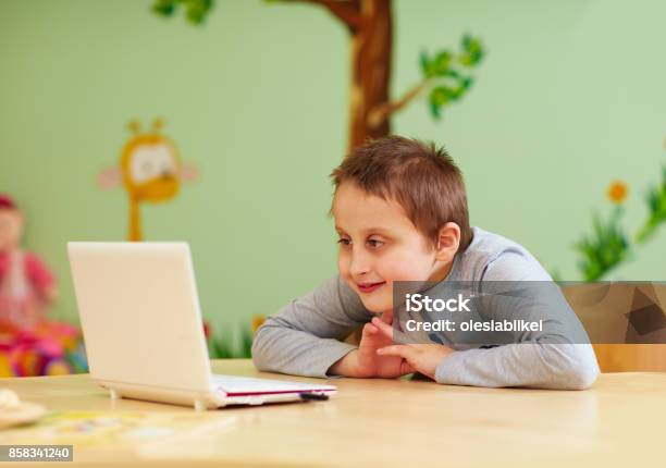 Young Boy With Special Needs Watching Media Through The Laptop Stock Photo - Download Image Now