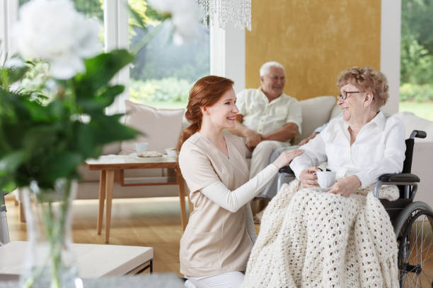 istock Caregiver kneeling by wheelchair 858341376