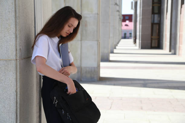 istock Girl student holding a folder in hands, college student, a school, 858348450