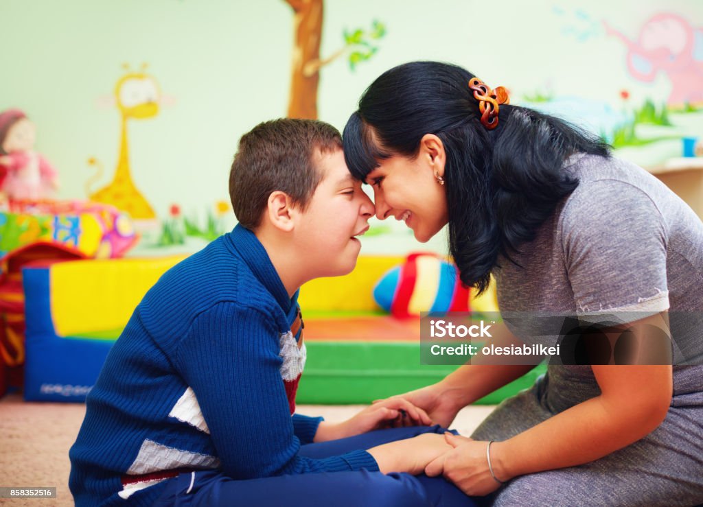 soulful moment. portrait of mother and her beloved son with disability in rehabilitation center Child Stock Photo