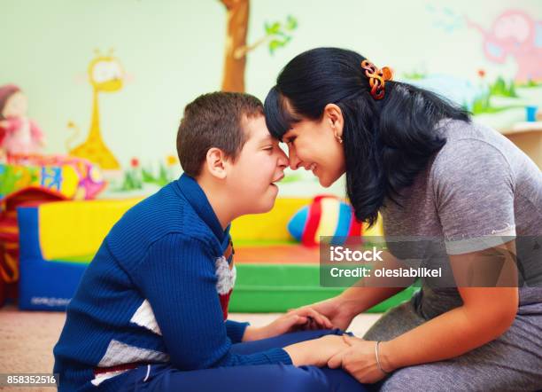 Soulful Moment Portrait Of Mother And Her Beloved Son With Disability In Rehabilitation Center Stock Photo - Download Image Now