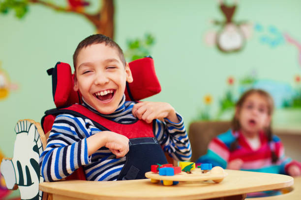 ragazzo allegro con disabilità al centro di riabilitazione per bambini con bisogni speciali - disabled accessible boarding sign foto e immagini stock