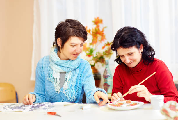 adult woman with special needs are engaged in handcraft in rehabilitation center adult woman with special needs are engaged in handcraft in rehabilitation center disabled adult stock pictures, royalty-free photos & images