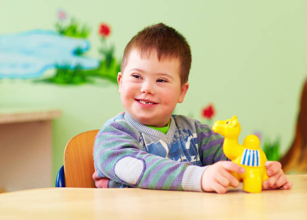 istock cute kid with down's syndrome playing in kindergarten 858358856