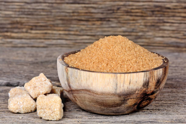 istock Sugar brown in a bowl with raw sugar on table 858370474