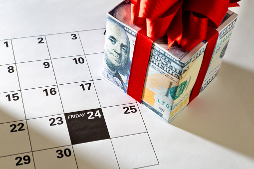 A calendar page with cash money gift box for the 2017, 2023 Black Friday retail shopping day, marking November 24 Friday, the day after Thanksgiving for the beginning of the Christmas shopping period.