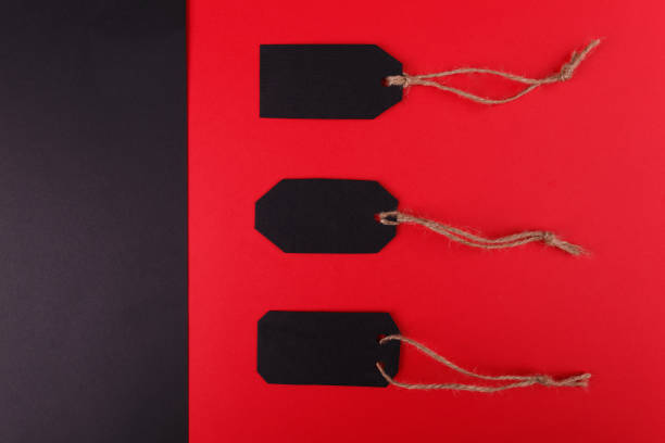 istock Black tags on a bright red background. The black background is empty. 858378160