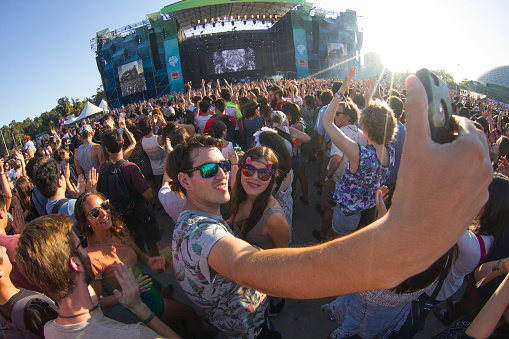 Santiago, Chile - March 19, 2017: Panoramic view of main stage of Lollapalooza at O'Higgins Park, one of the biggest music festivals in Chile. Couple taking a selfie with their cellphone.