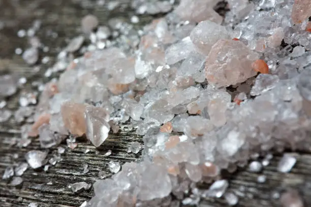 Himalayan pink salt crystals on old wooden table