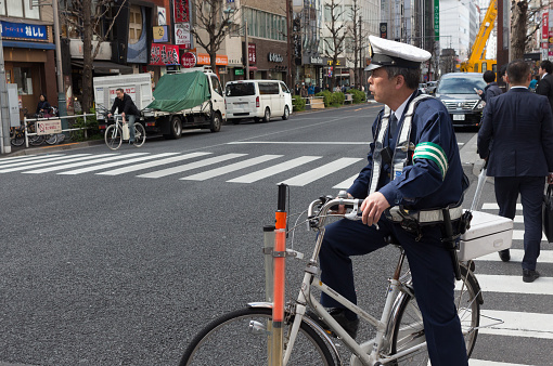 Tokyo: Japanese police man sitting on a bicycle in Tokyo, Japan.