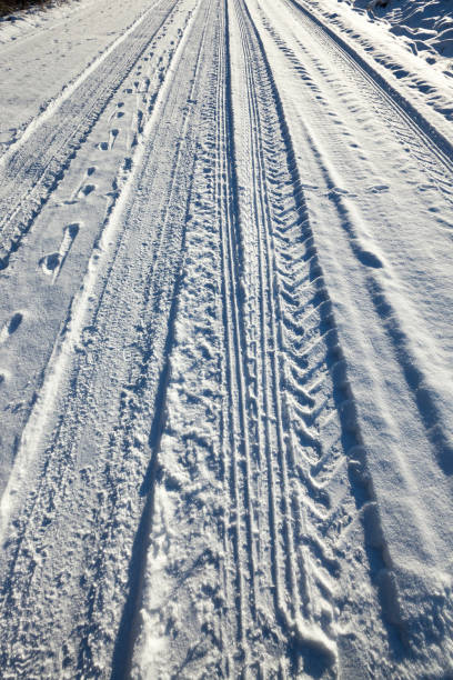 istock trace of the car wheels on snow close-up 858413010