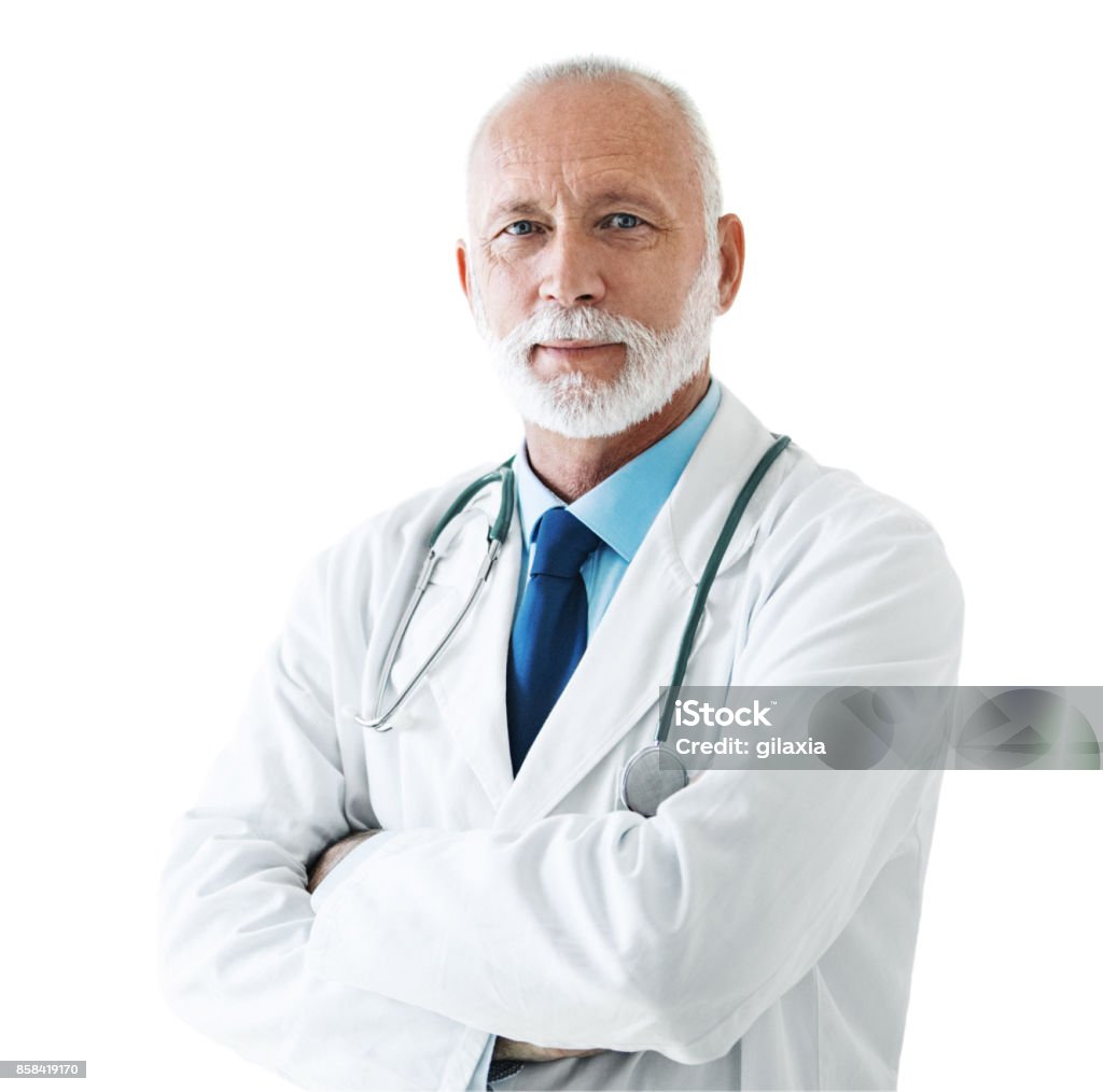 Senior male doctor. Closeup front view of a senior male doctor standing in front of a camera with his arms folded. Shot over white background. Doctor Stock Photo