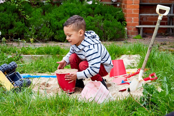 istock Cute boy playing in a sandbox in backyard 858434488