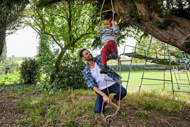 istock Child climbing rope ladder with father 858435032