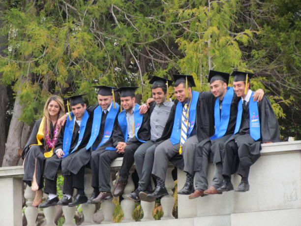 04/25/2015 Middletown Ct USA Graduation at Wesleyan University outdoors viwing crowd and ceremony from above with American flag and campus buildings in background.