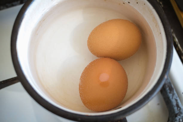 two brown boiled eggs in an enamel pot