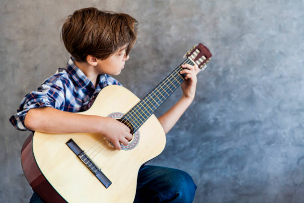 istock Cute teenage boy playing acustic guitar 858448440