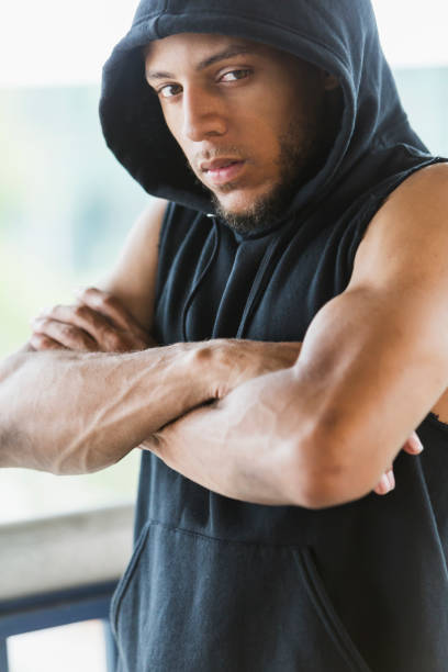 istock Young mixed-race man, serious expression, arms crossed 858448876