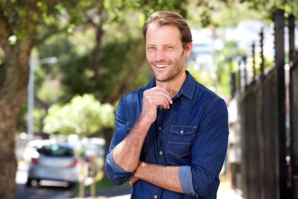 istock handsome man standing outside and smiling 858451660