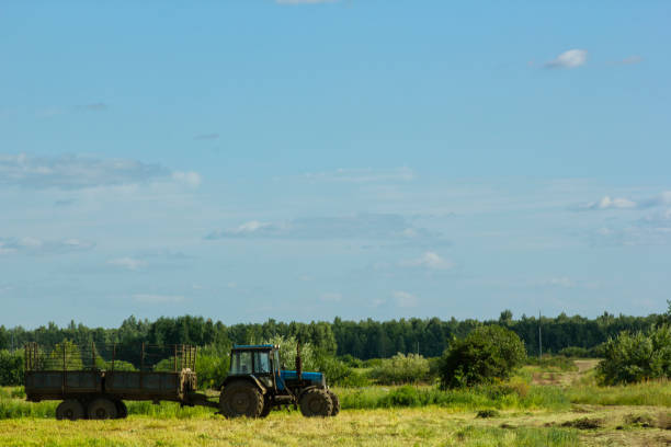istock Tractor running in the field against a blue sky background 858452804