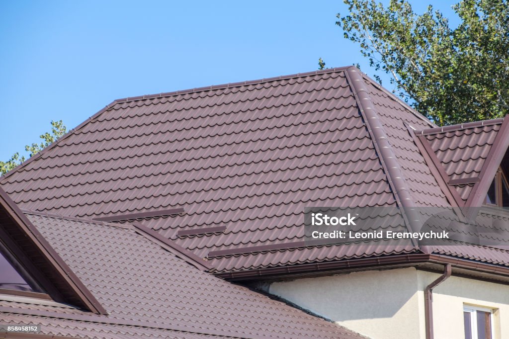 The roof of corrugated sheet. Brown corrugated metal profile roof. Brown corrugated metal profile roof. The roof of corrugated sheet. Roofing of metal profile wavy shape. Rooftop Stock Photo