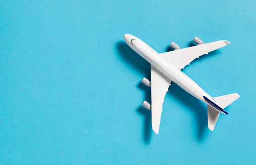 Miniature airplane isolated on blue background, with copy space