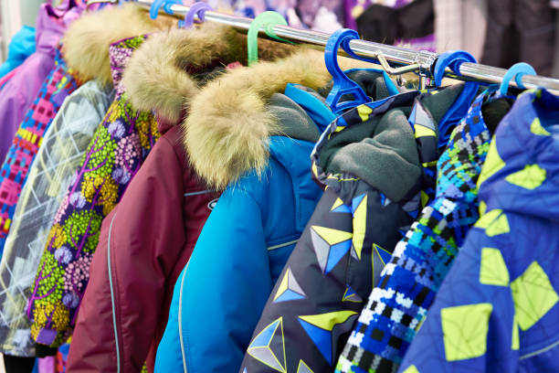 children winter jackets on hanger in store - coat imagens e fotografias de stock