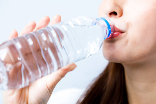 hydration concept. a young woman drinking a bottle of water. - water bottle water bottle drinking imagens e fotografias de stock