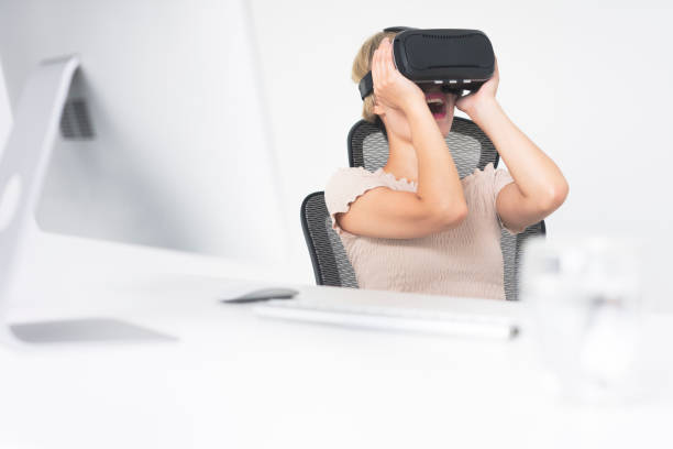 istock businesswoman wearing virtual reality simulator at office desk 858484900