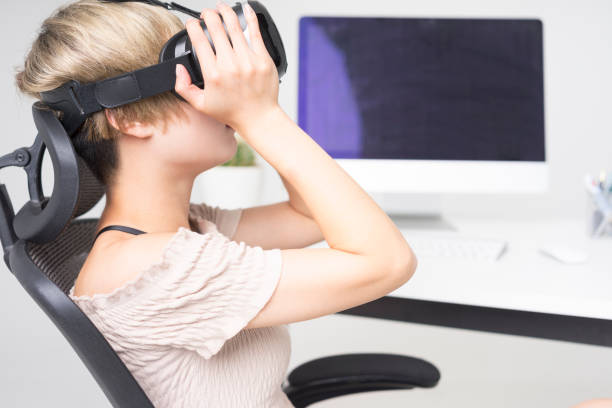 istock businesswoman wearing virtual reality simulator at office desk 858485036