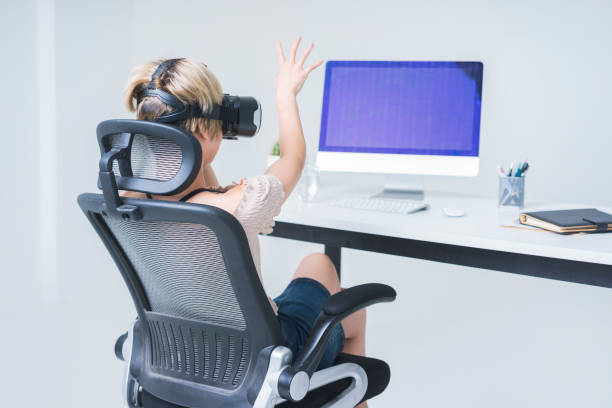 istock businesswoman wearing virtual reality simulator at office desk 858485202