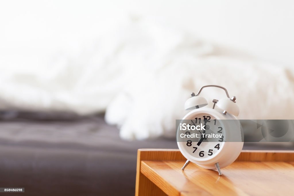 Good morning with alarm clock on bedside table Good morning with alarm clock on bedside table. Life in schedule concept. Easy awakening in light interior Alarm Stock Photo