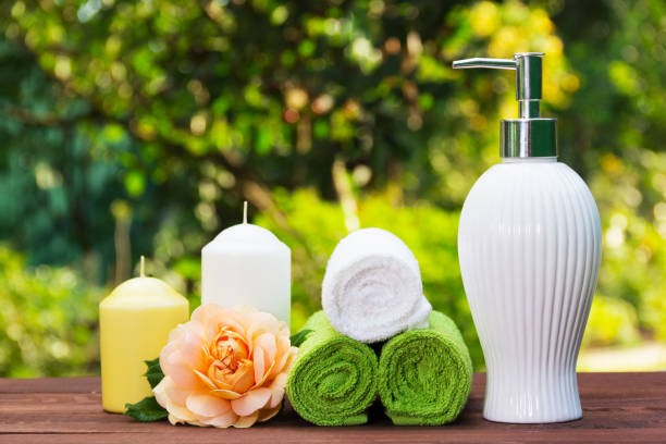 Liquid soap, a stack of towels, candles and a fragrant rose. Spa set for body care. Spa concept. stock photo