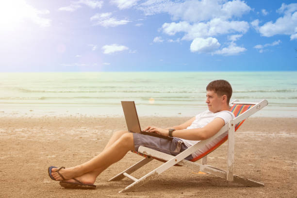 istock Young freelancer on sea beach in deck chair 858493852