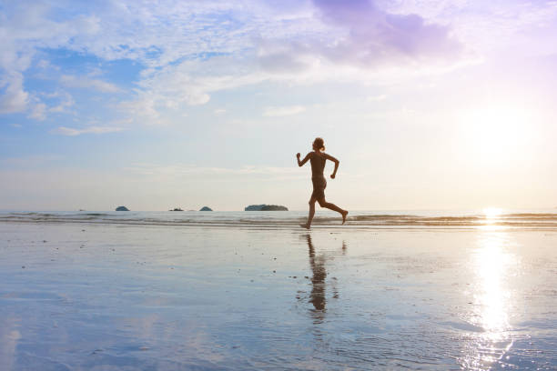 istock Young women are jogging on sunset sea beach. 858494256