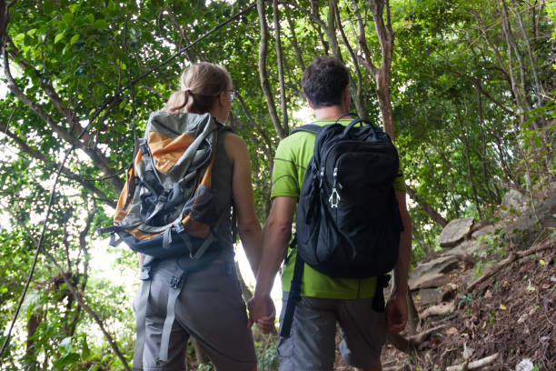 istock Young couple hikers in tropical jungle holding their hands. 858496436