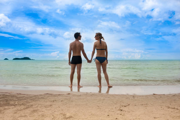 istock Young couple on beautiful seabeach is standing and holding hands 858498594
