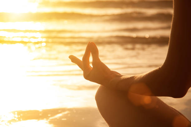 istock Young woman make meditation at sunset sea beach. Mudra gesture 858498718
