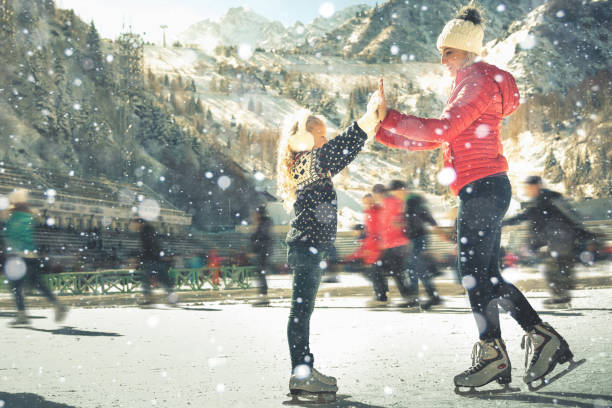 feliz familia al aire libre patinaje sobre hielo en pista. actividades de invierno - ice skating ice hockey child family fotografías e imágenes de stock