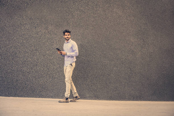 istock Businessman walking on street and using iPod. Space for copy. 858502734