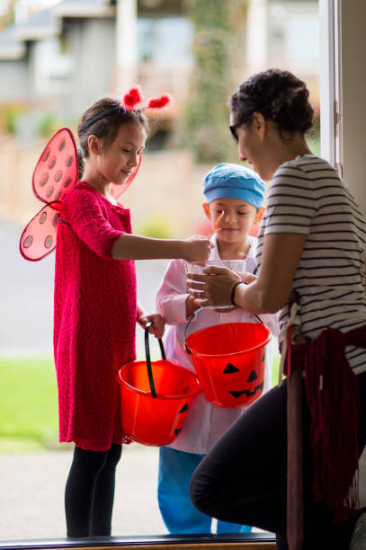 istock Two Children in Halloween Costumes Trick or Treating 858508526