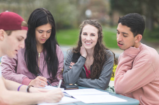 istock Multiethnic group of college students study outside at table together 858511122