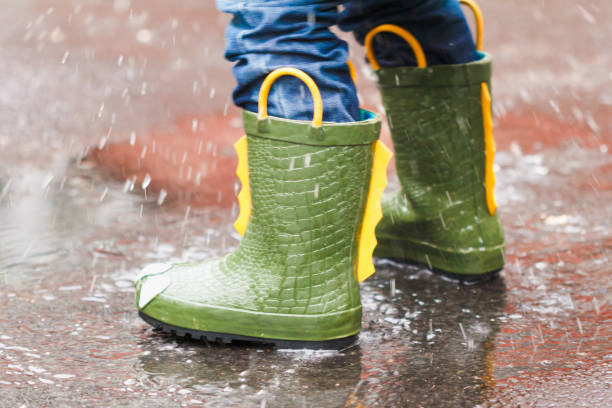 istock child with rain boots jumps into a puddle 858515468