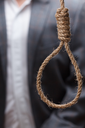 Man in a suit about to hang himself in the noose